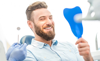 Man looking at smile in mirror