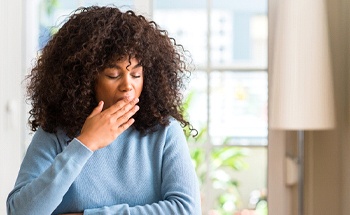 Restless person sitting at a table and yawning