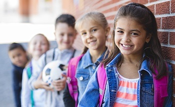 Smiling kids outside of school building