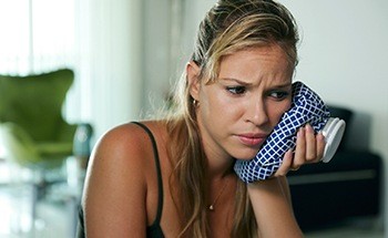 Woman holding ice pack to face