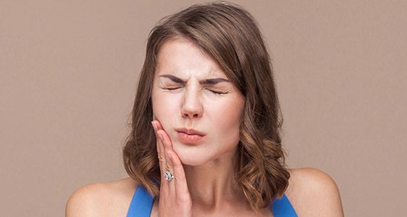 Woman holding her cheek in pain