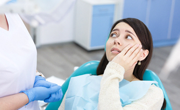 dental patient with toothache talking to dental professional about extraction