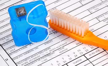 Toothbrush and floss on top of form for MetLife dental insurance in Woodstock