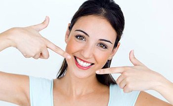 Woman pointing to her flawless smile