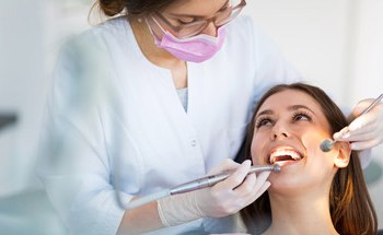 Woman in dental chair getting an oral cancer screening in Woodstock
