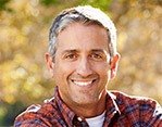 Smiling man in red plaid shirt outdoors