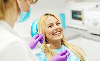 Woman laughing in dental chair after teeth whitening in Woodstock