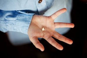 Hand holding a tooth fragment 